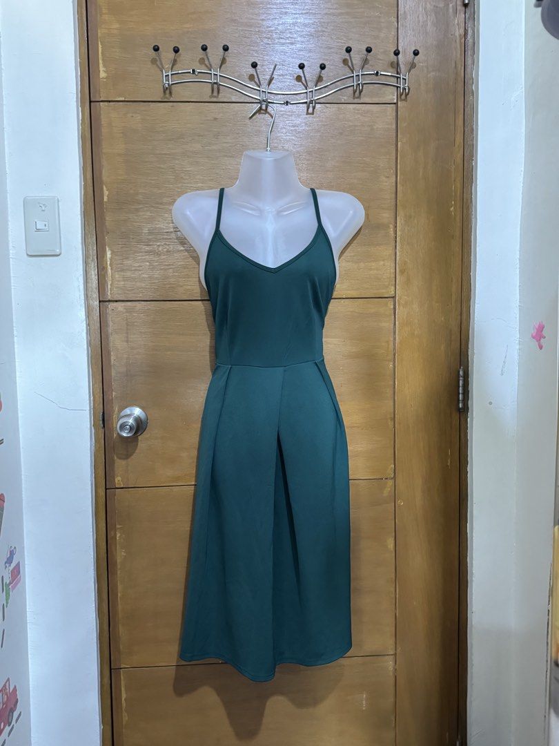 Dark Green Spaghetti Strap Midi Dress (Category: Dresses) located in Antipolo. Submitted by winsell (Listing ID 1471186112, Image 2). Description: - Color: Dark green - Style: Sleeveless midi dress with V-neckline - Back: Crossed adjustable straps - Details: Pleated skirt section, neat stitching - Length: Knee-length - Condition: Clean, ready to wear - Versatility: Great for casual or semi-formal occasions.