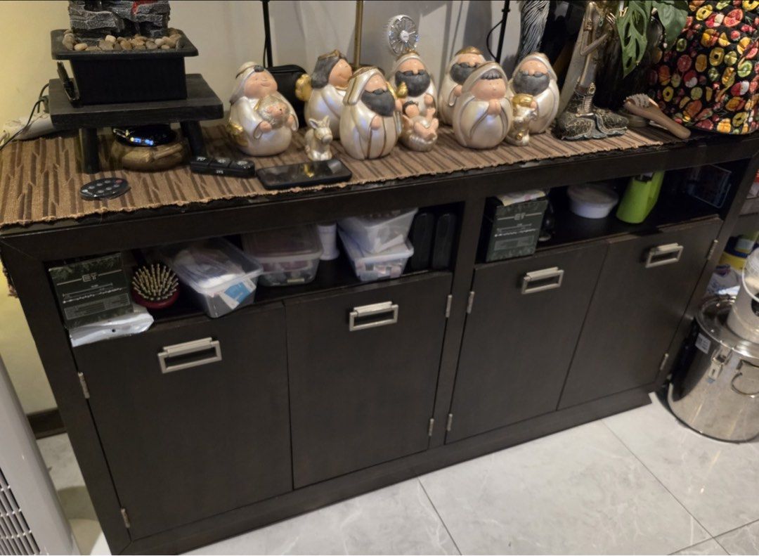 Dark Wood Buffet Sideboard Storage Cabinet with 4 Doors (Category: Shelves, Cabinets & Racks) located in San Jose del Monte. Submitted by jl_sant0s (Listing ID 1471126213, Image 1). Description: - Dark wood sideboard cabinet with neutral finish - Features 4 cabinet doors with sleek brushed silver handles - Ample interior storage with upper shelf compartments - Solid, sturdy construction sitting on a flat base - Versatile design matches various ho