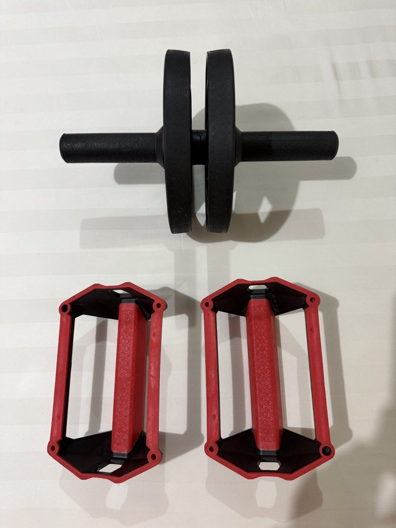 Decathlon Domyos Ab Roller and Push Up Bars SET (Category: Toning & Stretching Accessories) located in Marikina City. Submitted by kscanlas12 (Listing ID 1471179174, Image 2). Description: - Brand: Domyos - Includes: Dual ab wheel roller and two push-up handles - Color/Design: Black wheels with textured grips and red handles featuring a geometric pattern and Domyos logo - Ideal for: Home core workouts and upper body training - Condition: Minimal 