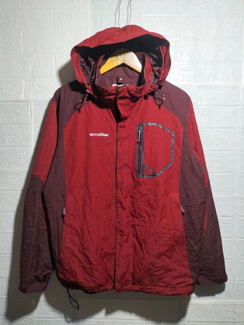 Echorova Red Hooded Outdoor Jacket (Category: Coats, Jackets and Outerwear) located in Valencia. Submitted by cabisaythriftshop (Listing ID 1471225717, Image 1). Description: - Brand: Echorova - Color: Red and maroon - Hood with adjustable drawstrings - Front zip closure with Velcro storm flap - Functional chest pocket with zip detailing - Adjustable Velcro cuffs for a better fit - Authentic brand label stitched inside the collar.