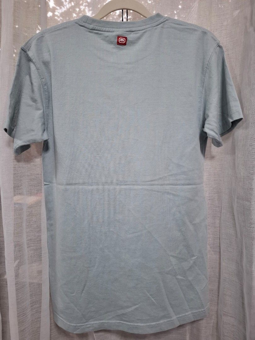 Ecko Unltd Graphic T-Shirt Light Blue Size S (Category: Tshirts & Polo Shirts ) located in Manila. Submitted by jazil.ladyliz (Listing ID 1471196939, Image 3). Description: - Brand: Ecko Unltd - Size: S (Regular fit) - Color: Light blue - Material: 100% cotton - Design: Front graphic print with female face art, 'FEMALE' text, and red accent patch - Details: Woven brand tags at the bottom hem and back collar - Condition: Excellent pre-loved find.