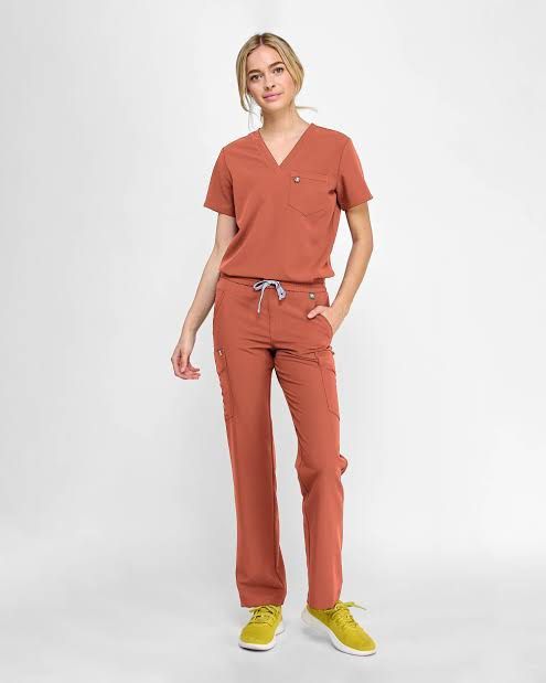 FIGS Rust Orange Scrubs Set Top and Pants (Category: Sets or Coordinates) located in Davao. Submitted by .lille (Listing ID 1471283781, Image 3). Description: FIGS scrubs set in a rust orange shade. V-neck top with chest pocket and branded logo tag. Matching pants with a wide ribbed waistband and adjustable pink drawstring. Multiple pockets including a zippered cargo pocket on the right leg. Technical collection fabric, lightweight and stretchy. 