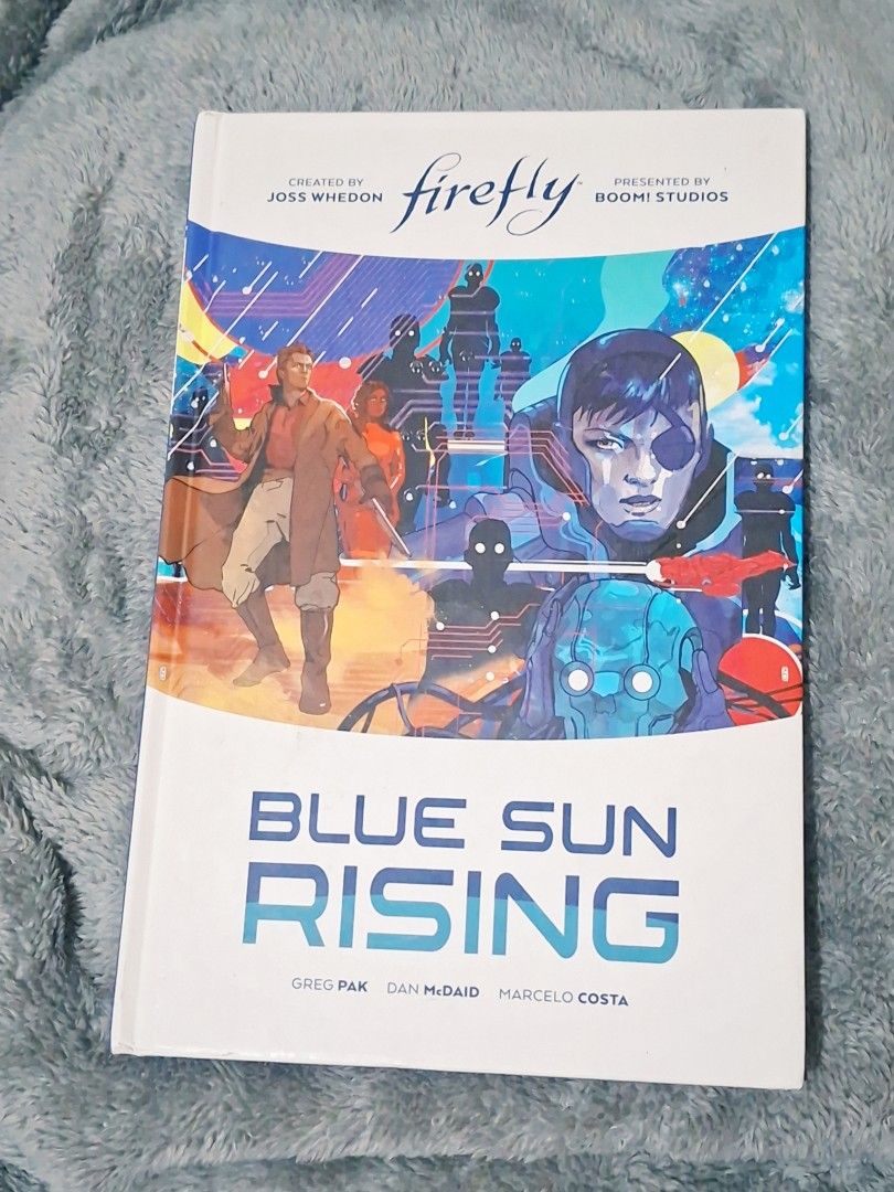Firefly Blue Sun Rising Graphic Novel Boom Studios (Category: Comics & Manga) located in Pasay City. Submitted by riririju (Listing ID 1471213172, Image 1). Description: - Title: Firefly: Blue Sun Rising Graphic Novel - Publisher: Boom Studios (Created by Joss Whedon) - Creators: Written by Greg Pak, art by Dan McDaid & Marcelo Costa - Format: Softcover - Condition: Clean cover, crisp pages, minimal shelf wear at corners.