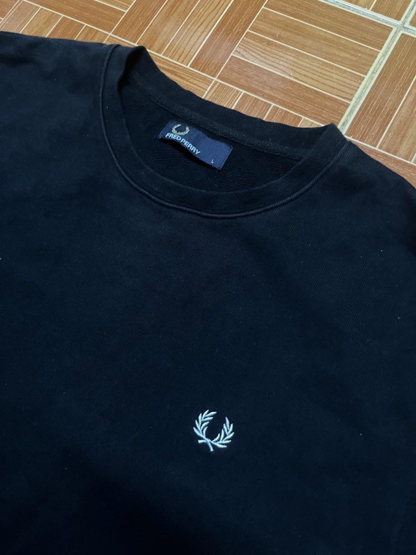 Fred Perry Black Crewneck Sweatshirt Size L (Category: Coats, Jackets and Outerwear) located in Manila. Submitted by jlfamiliar69452 (Listing ID 1471146749, Image 2). Description: - Brand: Fred Perry - Item: Crewneck Sweatshirt - Color: Black with white embroidered laurel wreath logo - Size: L (Tag on collar) - Details: Striped ribbed cuffs and hem, classic pullover style - Origin: Made in China - Style Code: M2599.