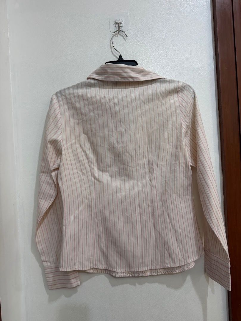 G2000 Long-sleeve Striped Button-down Blouse with Ruffled Placket Polo (Category: Longsleeves) located in Quezon City. Submitted by decluttering_alot (Listing ID 1471183120, Image 3). Description: - Color & Pattern: Cream and pink stripes - Design: Decorative ruffled front placket, classic collar, and wide button cuffs - Fit: Tailored and structured silhouette - Versatility: Ideal for office wear or casual outings - Condition: Clean, well-structu