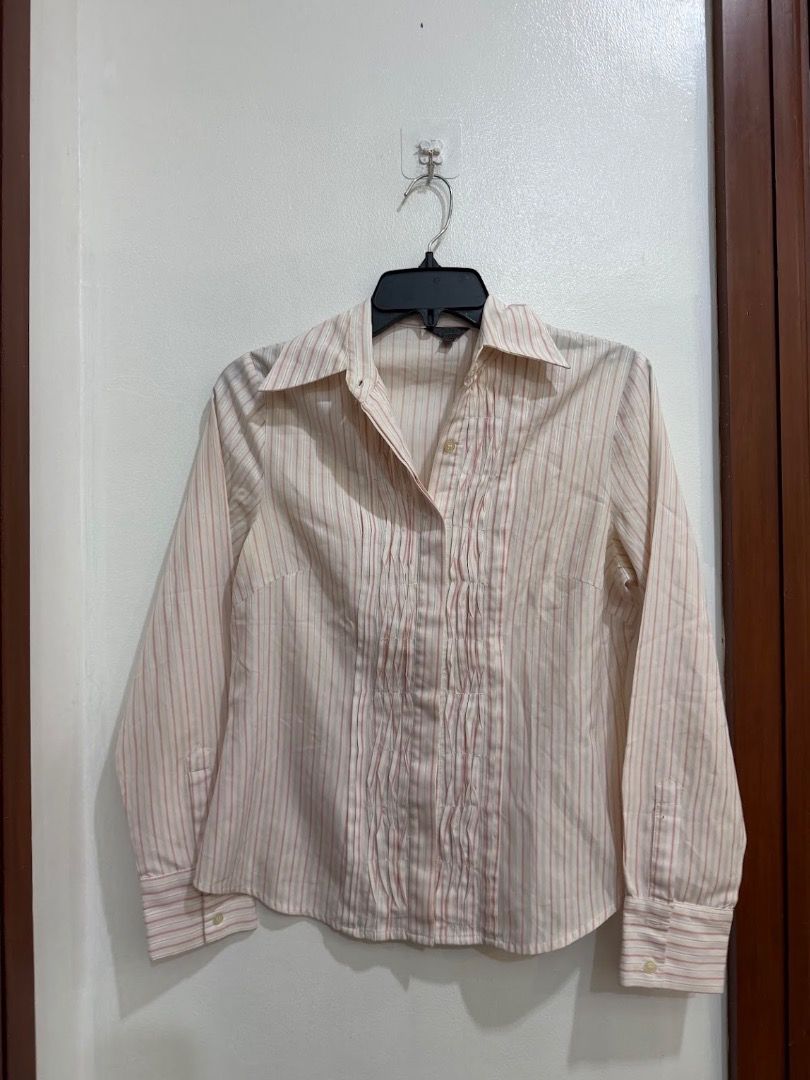 G2000 Long-sleeve Striped Button-down Blouse with Ruffled Placket Polo (Category: Longsleeves) located in Quezon City. Submitted by decluttering_alot (Listing ID 1471183120, Image 1). Description: - Color & Pattern: Cream and pink stripes - Design: Decorative ruffled front placket, classic collar, and wide button cuffs - Fit: Tailored and structured silhouette - Versatility: Ideal for office wear or casual outings - Condition: Clean, well-structu