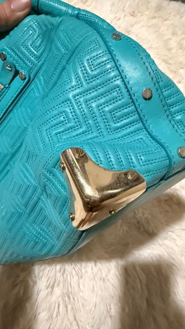 Gianni Versace Couture Teal Shoulder Bag (Category: Luxury Bags & Wallets) located in Pasay City. Submitted by erinsclosetph (Listing ID 1471219748, Image 2). Description: Gianni Versace Couture Teal Shoulder Bag Features a beautiful teal finish. Well-used preloved condition with visible signs of wear, including rubs on the leather and handles, scratches on the metal hardware, and a minor stain on the interior lining. More pictures available upon