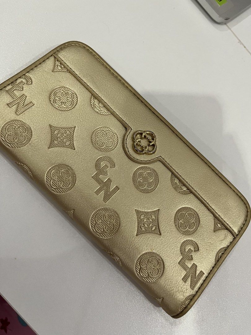 Gold patterned long wallet with multiple card slots and zipper pocket (Category: Wallets & Card holders) located in Rizal. Submitted by oncelove143 (Listing ID 1471142428, Image 1). Description: - Elegant gold wallet with an all-over embossed pattern - Secure front flap with snap button closure - Multiple card slots inside for organized storage - Convenient back zippered compartment for coins and small essentials - Chic gold-tone hardware on the 