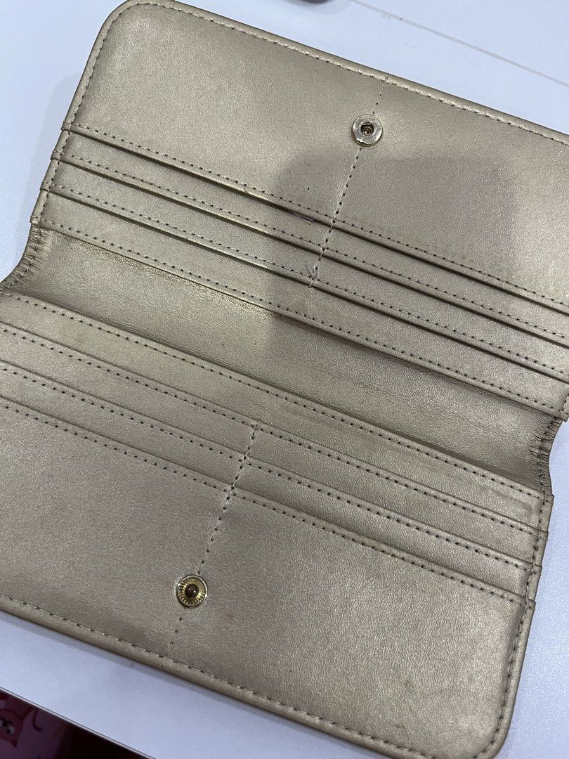 Gold patterned long wallet with multiple card slots and zipper pocket (Category: Wallets & Card holders) located in Rizal. Submitted by oncelove143 (Listing ID 1471142428, Image 3). Description: - Elegant gold wallet with an all-over embossed pattern - Secure front flap with snap button closure - Multiple card slots inside for organized storage - Convenient back zippered compartment for coins and small essentials - Chic gold-tone hardware on the 