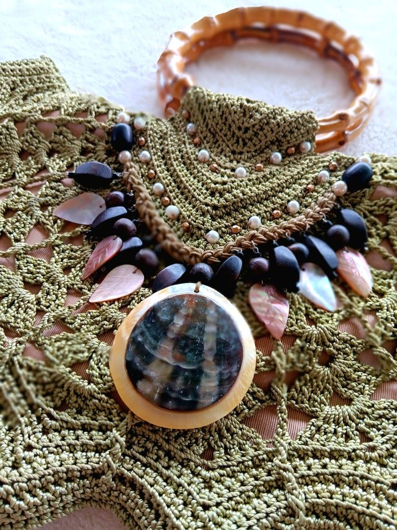 Green Crochet Handbag Bamboo Handle Shell Beaded Statement Bag (Category: Shoulder Bags) located in Pateros City. Submitted by sphinxvillanueva (Listing ID 1471216967, Image 2). Description: - Handcrafted olive green crochet handbag in a stylish boho summer design - Features a sturdy round bamboo top handle and secure zippered interior - Embellished front flap with wooden beads, mother-of-pearl leaves, and a large shell statement pendant - Beauti