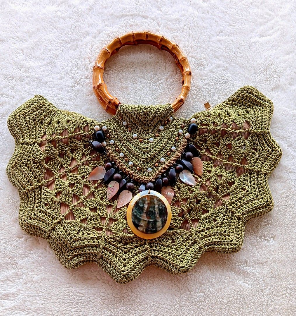 Green Crochet Handbag Bamboo Handle Shell Beaded Statement Bag (Category: Shoulder Bags) located in Pateros City. Submitted by sphinxvillanueva (Listing ID 1471216967, Image 1). Description: - Handcrafted olive green crochet handbag in a stylish boho summer design - Features a sturdy round bamboo top handle and secure zippered interior - Embellished front flap with wooden beads, mother-of-pearl leaves, and a large shell statement pendant - Beauti