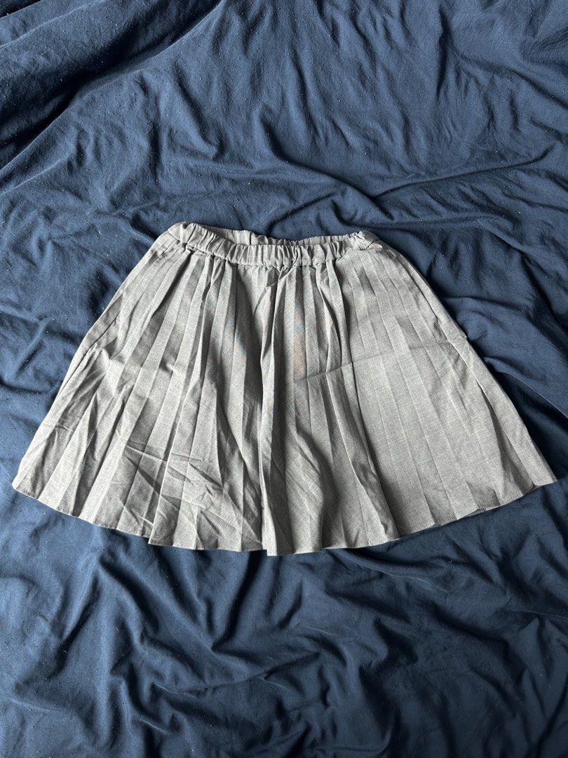 Grey Pleated Mini Skirt (Category: Skirts) located in Quezon City. Submitted by valeriorac74670 (Listing ID 1471179295, Image 1). Description: - Color: Grey - Style: High-waisted mini skirt with all-around pleated texture - Fit: Comfortable and stretchy with an elastic waistband - Length: Short, hits right above the knee - Material: Lightweight and soft - Pairing: Looks great with basic white tank tops or tees.