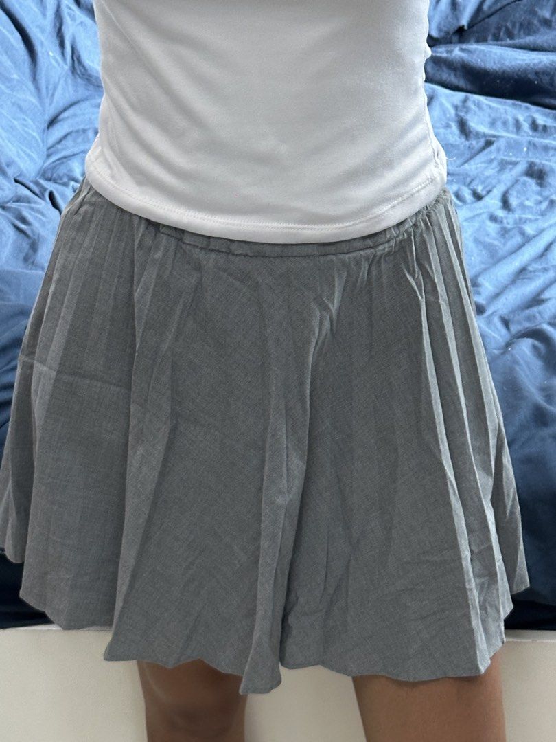 Grey Pleated Mini Skirt (Category: Skirts) located in Quezon City. Submitted by valeriorac74670 (Listing ID 1471179295, Image 2). Description: - Color: Grey - Style: High-waisted mini skirt with all-around pleated texture - Fit: Comfortable and stretchy with an elastic waistband - Length: Short, hits right above the knee - Material: Lightweight and soft - Pairing: Looks great with basic white tank tops or tees.