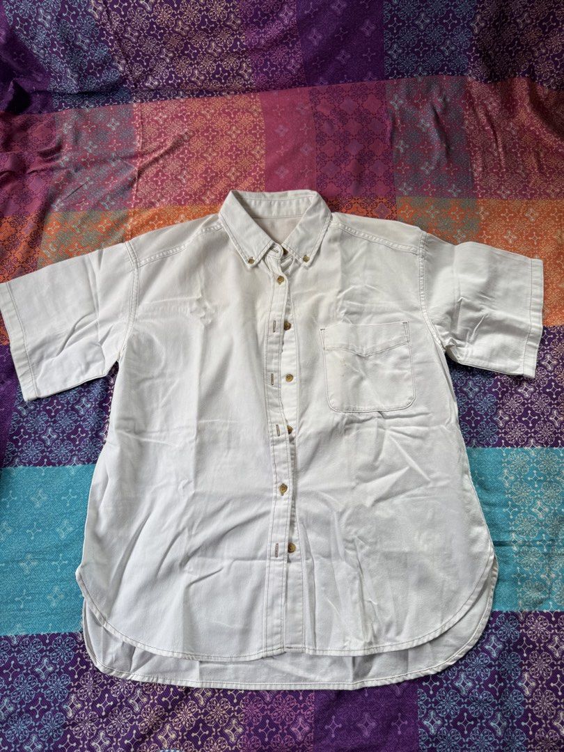 GU White Short Sleeve Button-Down Shirt (Category: Shirts) located in Quezon City. Submitted by mymelodylvr (Listing ID 1471286538, Image 1). Description: - Brand: GU - Color: Classic White - Material: 100% Cotton - Details: Short sleeves, button-down collar, single chest pocket, curved hem - Condition: Good overall, but please note small stains on the front pocket - Style: Casual basic top, easy to pair with denim or shorts.