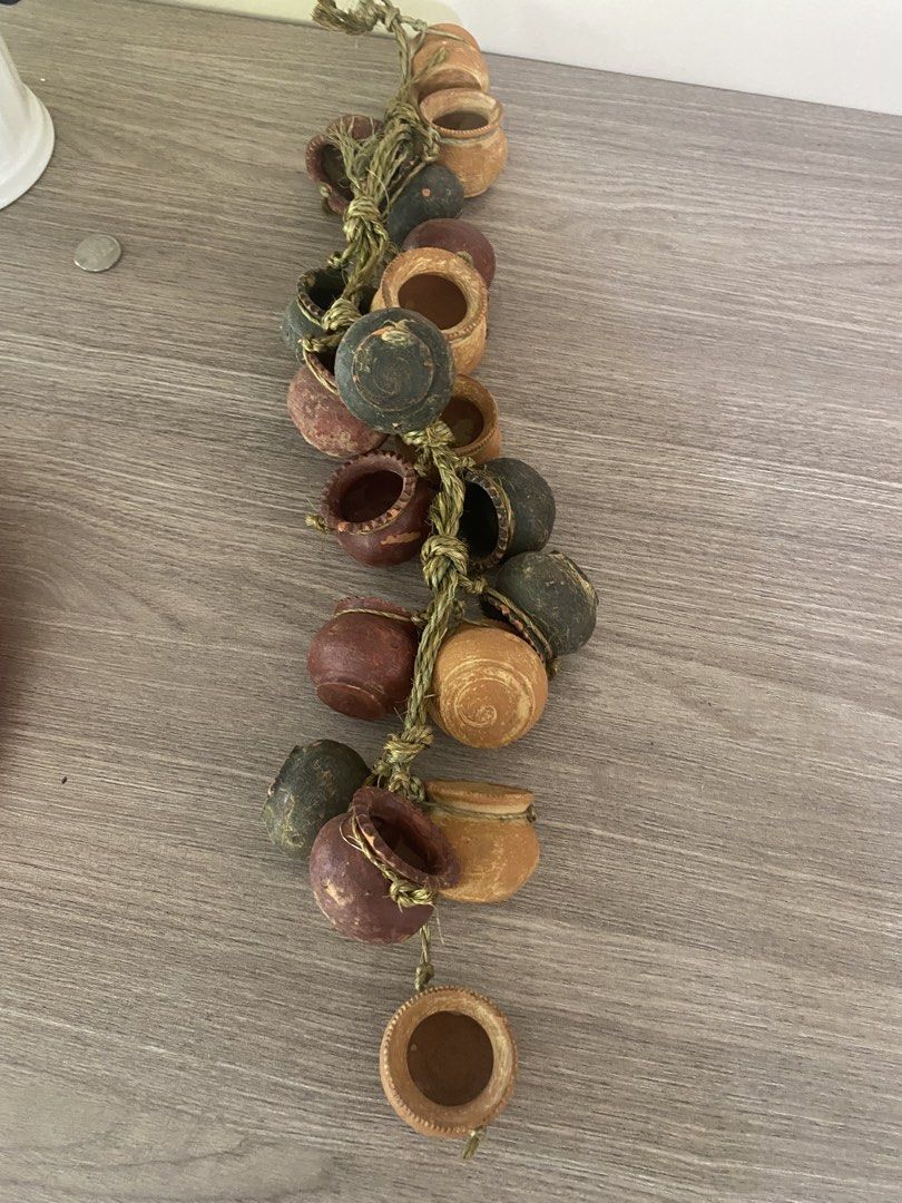 Hanging Garlic Ceramic and Miniature Pots Bundle Decor (Category: Wall Decor) located in Santa Rosa. Submitted by hoardqueensdeclutter (Listing ID 1471241616, Image 2). Description: - Set of 2 unique hanging decorative pieces for kitchen or dining room - Strand 1: Ceramic garlic bulbs in charming pink and white with a rustic rope loop - Strand 2: Miniature terracotta-style pots in mixed earthy tones tied with twine - Versatile display: Easily han