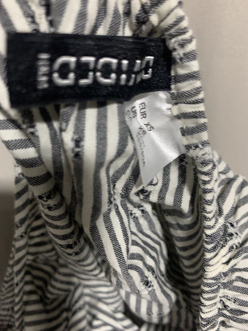 H&M Divided Striped Camisole Top (Category: Sleeveless) located in Manila. Submitted by decluterthings888 (Listing ID 1471232724, Image 2). Description: - Brand: H&M Divided - Size: XS - Color/Pattern: Black and white stripes - Details: Adjustable tie shoulder straps, scalloped hem with eyelet embroidery - Material: Lightweight fabric, ideal for warm weather - Condition: Worn a few times, still in very good shape - Styling: Perfect to match with 