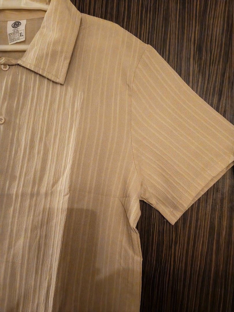 INSPI Short Sleeve Button Down Shirt Beige XL (Category: Tshirts & Polo Shirts ) located in Las Pinas. Submitted by sam_twin_d (Listing ID 1471125976, Image 2). Description: - Brand: INSPI - Color: Beige with textured vertical stripes - Size: XL - Style: Short sleeve button-down with classic collar - Material: Cotton blend (machine washable) - Condition: Clean and neatly hung.
