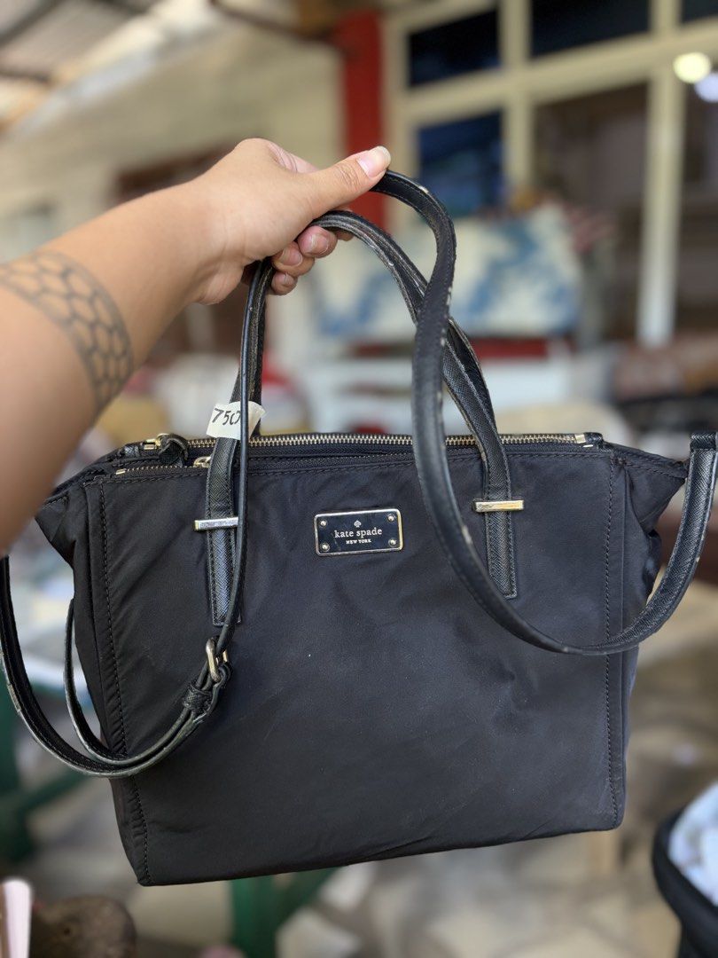 Kate Spade Black Nylon Tote Handbag (Category: Tote Bags) located in Manila. Submitted by dorilorenr48954 (Listing ID 1471227270, Image 1). Description: - Brand: Kate Spade New York - Material: Durable black nylon with gold-tone hardware - Versatile Carry: Includes double top handles and a long adjustable shoulder strap - Interior: Signature monogram lining with a secure zippered pocket and convenient compartments - Perfect for work, school, or d
