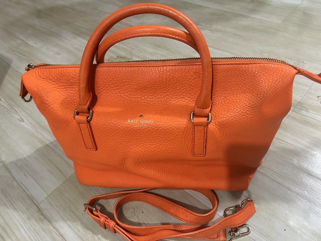 Kate Spade Orange Leather Satchel Bag (Category: Luxury Bags & Wallets) located in Manila. Submitted by ai010 (Listing ID 1471211182, Image 1). Description: - Brand: Kate Spade New York - Material: Vibrant orange pebble leather with silver-tone hardware - Closure: Secure zip-top closure - Carrying Options: Dual top handles and a detachable, adjustable crossbody strap - Interior: Clean cream fabric lining with signature text pattern, 1 zip pocket,