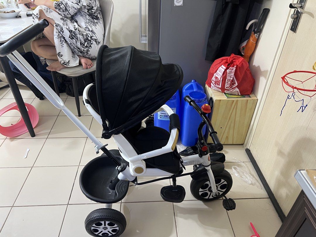 Kids Tricycle Stroller with Canopy and Parent Push Handle (Category: Strollers) located in Manila. Submitted by renattahan (Listing ID 1471285997, Image 1). Description: NEGOTIABLE FOR SURE BUYER White and black toddler tricycle with sun canopy, parent push handle, safety guardrail, and rear storage. Features front pedals and middle footrests. Clean and ready to use!.