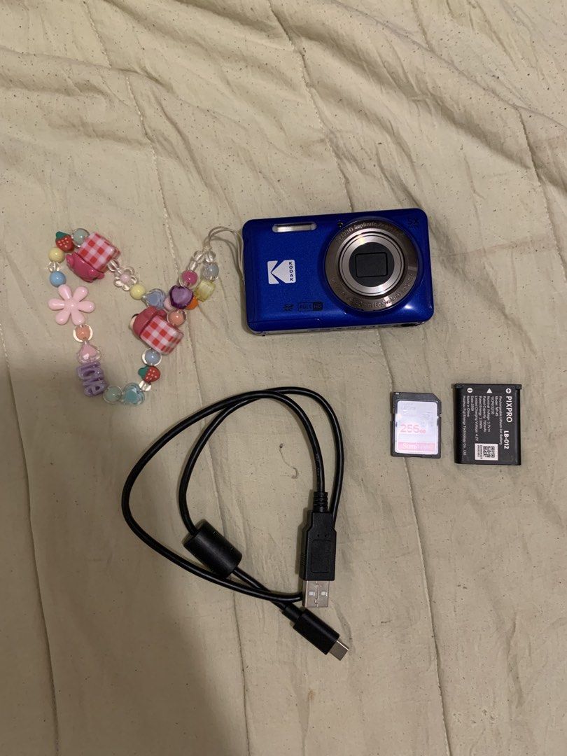 Kodak PixPro Blue Digital Camera Full HD (Category: Cameras) located in Valenzuela. Submitted by astridceleste (Listing ID 1471292156, Image 2). Description: - Model: Blue Kodak PixPro digital camera - Features: 5X wide zoom lens and Full HD recording capability - Condition: Fully working, perfect for trips and daily snaps - Inclusions: Custom beaded wrist strap, rechargeable battery, 256GB memory card, and USB charging cable 📸 KODAK PIXPRO FZ55