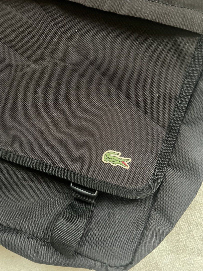 Lacoste Black Messenger Bag Crossbody (Category: Sling Bags) located in Cagayan de Oro. Submitted by nelsondel21723 (Listing ID 1471168287, Image 3). Description: Black Lacoste messenger bag. Durable canvas material with adjustable shoulder strap. Flap closure featuring dual plastic buckles and embroidered green crocodile logo in the corner. Zip pocket on the front flap with pull cords. Spacious interior compartment with fabric lining. Great ever