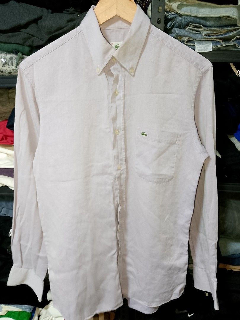 Lacoste button-down long sleeve shirt size 38 lilac (Category: Longsleeves) located in Manila. Submitted by mjthrifted_second (Listing ID 1471193249, Image 1). Description: - Brand: Lacoste (Manufactured by Devanlay) - Color: Light purple / Lilac - Size: 38 -Dimes: 20/28 - Material: 100% Cotton - Design: Classic button-down with front chest pocket and signature green crocodile logo - Sleeves: Long sleeves with button cuffs - Condition: Excellent 