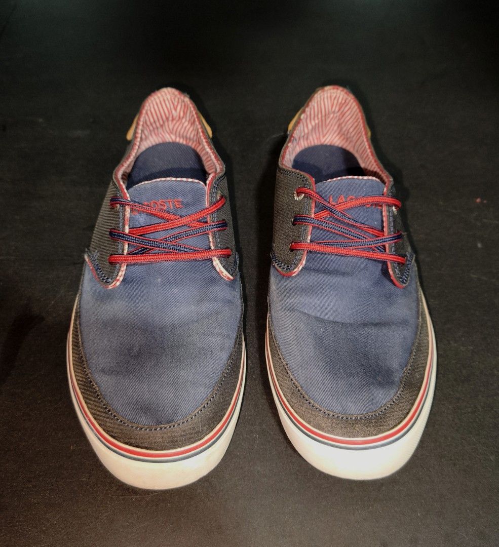 Lacoste Navy Blue Casual Sneakers (Category: Sneakers) located in Cavite. Submitted by billcleantone (Listing ID 1471237719, Image 3). Description: - Brand: Lacoste - Color: Navy blue with red and white accents - Size: Available upon request - Condition: Pre-loved, clean uppers with minimal wear on tread - Features: Low-top design, striped inner lining, stylish red patterned laces, white rubber sole with red bottom, and brown leather heel tab - P