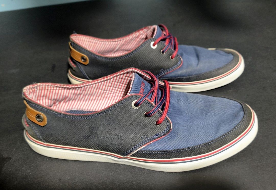 Lacoste Navy Blue Casual Sneakers (Category: Sneakers) located in Cavite. Submitted by billcleantone (Listing ID 1471237719, Image 1). Description: - Brand: Lacoste - Color: Navy blue with red and white accents - Size: Available upon request - Condition: Pre-loved, clean uppers with minimal wear on tread - Features: Low-top design, striped inner lining, stylish red patterned laces, white rubber sole with red bottom, and brown leather heel tab - P