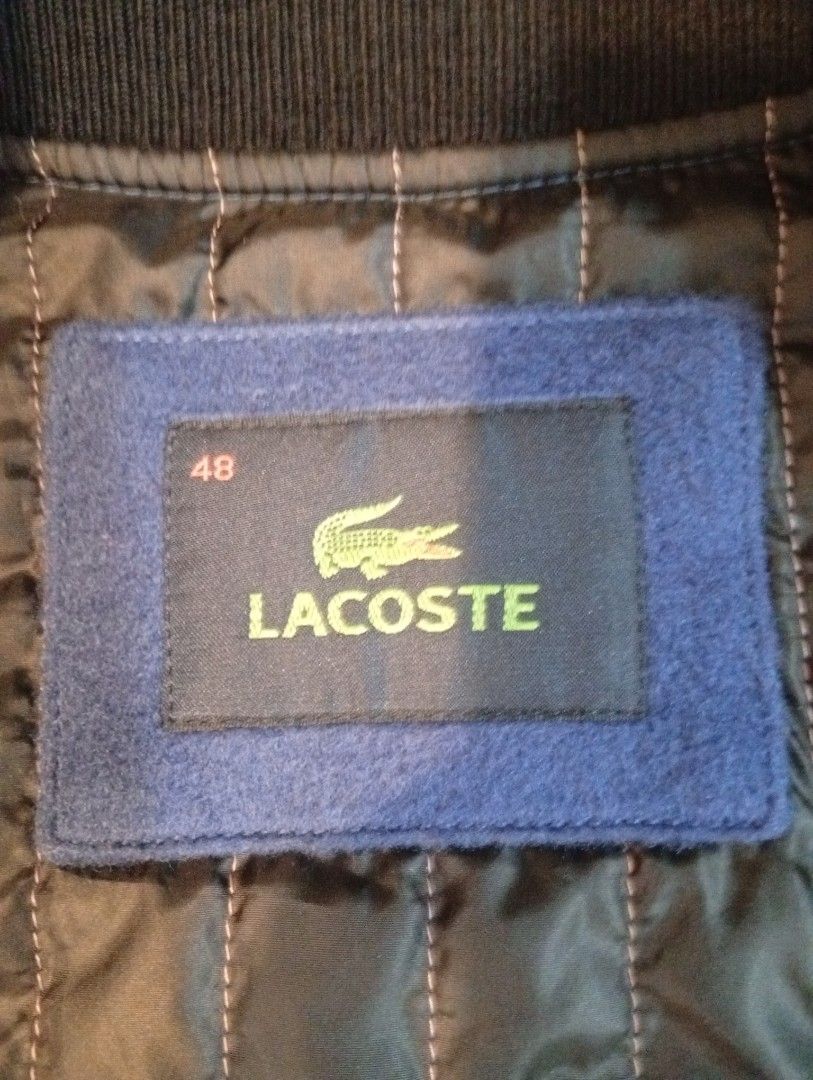 Lacoste Varsity Bomber Jacket Blue Black Size 48 (Category: Coats, Jackets and Outerwear) located in Cebu City. Submitted by jeanyrose46 (Listing ID 1471281647, Image 2). Description: - Classic varsity jacket style with blue wool body and black leather sleeves - Size 48 (labeled on inner brand tag) - Warm quilted black inner lining - Snap-button front closure with two functional welt pockets - Ribbed collar and cuffs featuring white striping - Cl