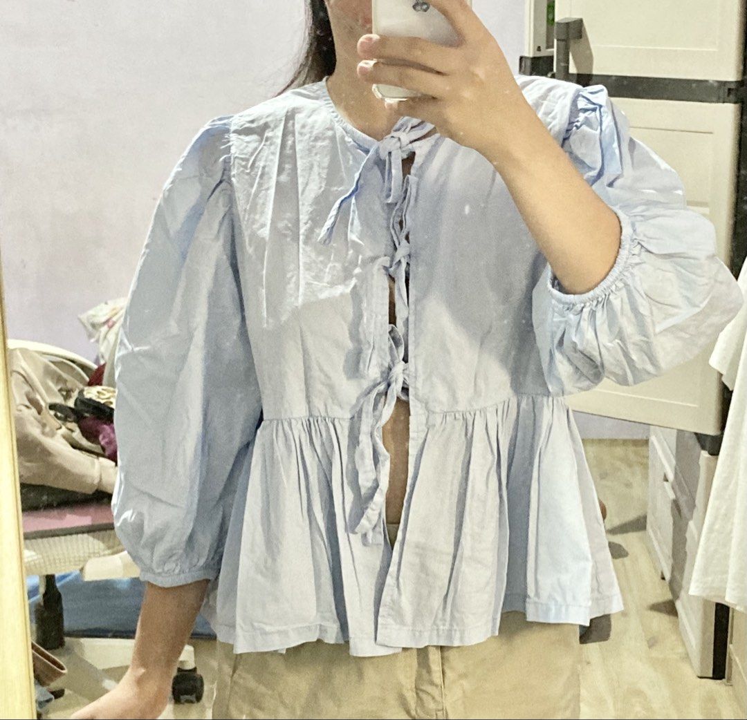 Light blue front-tie peplum blouse with puff sleeves (Category: Blouses) located in Meycauayan. Submitted by prettycloset.0310 (Listing ID 1471170740, Image 2). Description: Light blue cotton-blend blouse featuring front ribbon ties, puff sleeves, and a peplum waist. Medium. .