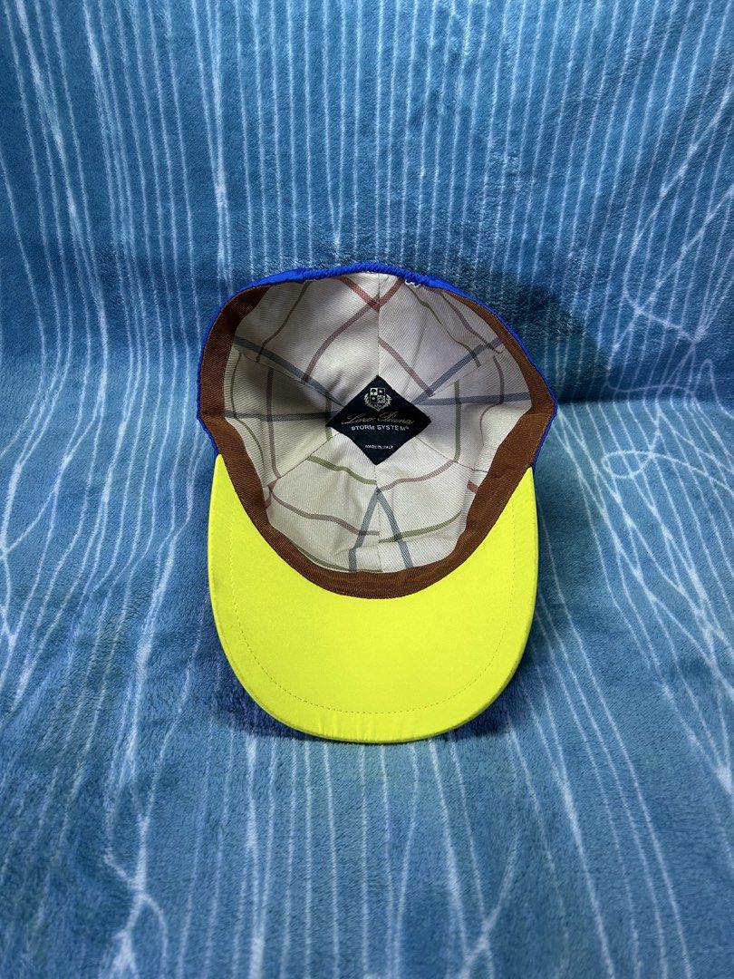 Loro Piana Storm System Baseball Cap Blue (Category: Caps & Hats) located in Quezon City. Submitted by thriftxgoods (Listing ID 1471252642, Image 3). Description: - Authentic Loro Piana baseball cap in royal blue - Embroidered crest and Italian flag detail on the front - Contrast yellow underside on the brim - Signature plaid pattern lining with Storm System tag - Made in Italy - Adjustable elastic back strap for a comfortable fit - Excellent, cl