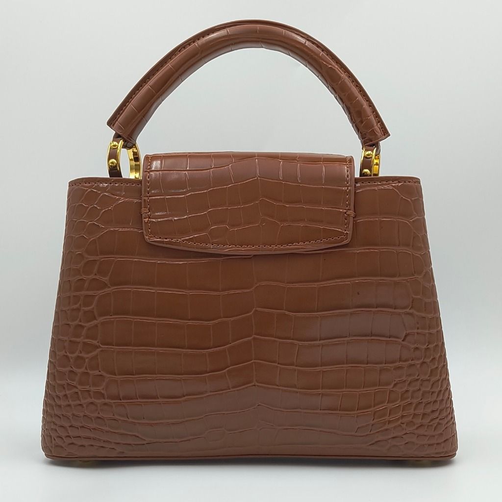 Louis Vuitton Capucines BB Flower Crown Croc Brown (Category: Luxury Bags & Wallets) located in Cebu City. Submitted by affordabagss (Listing ID 1471186844, Image 3). Description: Louis Vuitton Capucines BB Flower Crown Top Handle Bag in cognac brown crocodile-embossed leather with a structured silhouette. The design features a signature LV emblem, distinctive flower crown detailing, and gold-tone hardware with white enamel accents. A curved leat