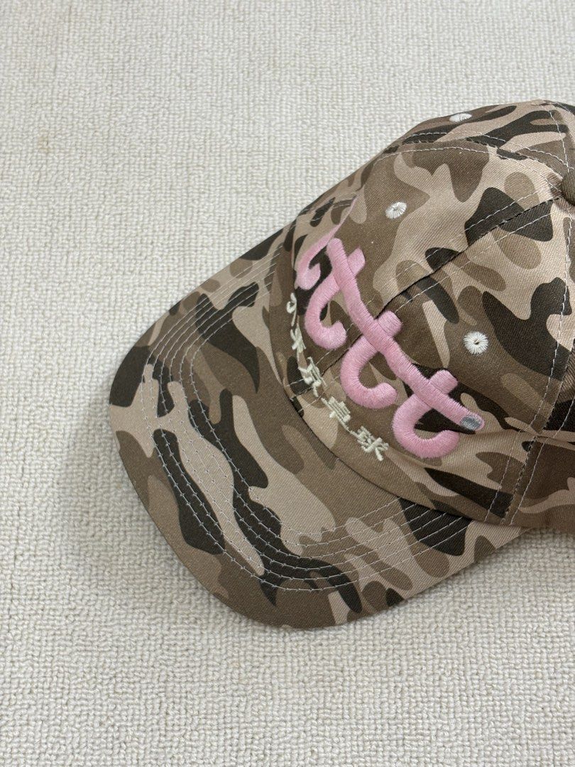 lttt Poch Camouflage Baseball Cap (Category: Caps & Hats) located in Manila. Submitted by porma.market (Listing ID 1471271835, Image 1). Description: - Brown camouflage cap - Pink raised embroidery with Japanese characters on the front - White eyelets and matching top button - Unique side label with 'lttt Poch' and a small blue tag - Adjustable strap at the back for a custom fit.