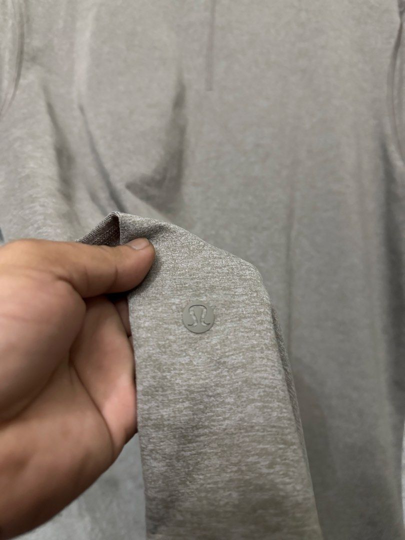 Lululemon Men's Grey Athletic T-Shirt (Category: Tshirts & Polo Shirts ) located in Quezon City. Submitted by stre3tw3ar (Listing ID 1471273313, Image 3). Description: - Brand: Lululemon - Style: Men's short sleeve athletic t-shirt - Color: Grey marl - Details: Round neckline, signature logo printed near the sleeve hem - Material: Breathable athletic fabric - Condition: Clean overall, great for gym or everyday wear.