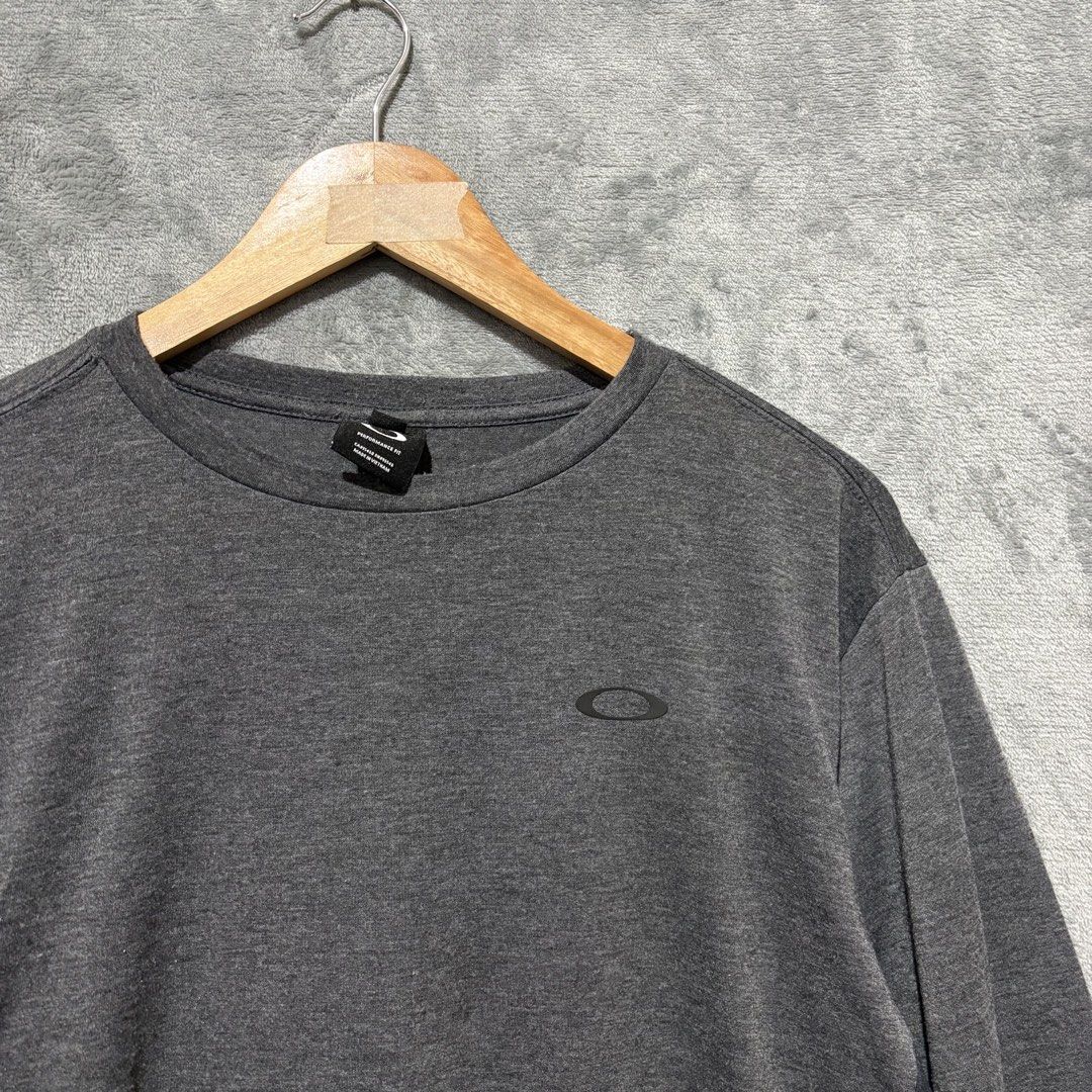 M - Oakley "Evolution Never Stops" Long Sleeve Shirt Heather Grey Performance Fit (Category: Tshirts & Polo Shirts ) located in Tuguegarao City. Submitted by past10 (Listing ID 1471280462, Image 2). Description: Upgrade your streetwear rotation with this authentic Oakley Performance Fit long-sleeve tee. Featuring a clean heathered dark grey base accented by bold typographic side-panel sleeve graphics, this piece strikes the perfect balance betwee