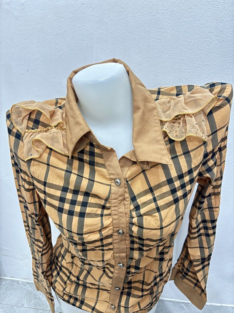 M Vintage Plaid Button-Down Blouse with Ruffled Shoulders (Category: Blouses) located in Manila. Submitted by urechicthrftmnl (Listing ID 1471166719, Image 2). Description: - Color & Pattern: Tan and black plaid - Closure: Front button closure with gathered ruching down the placket - Details: Ruffled mesh shoulders with tiny stud embellishments - Back Accent: Vertical strip of rhinestones down the center back - Cuffs: Button cuffs for an adjustab