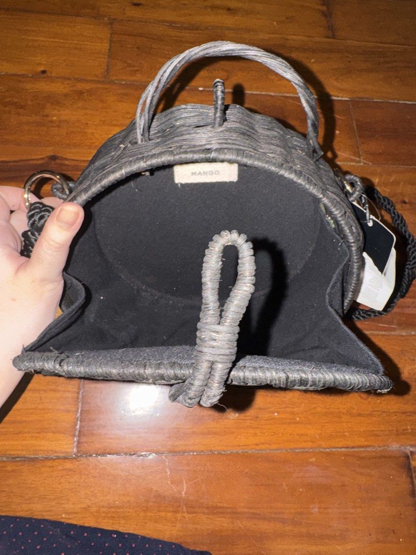 Mango Black Round Woven Crossbody Bag (Category: Cross-body Bags) located in Manila. Submitted by coclosets (Listing ID 1471200469, Image 2). Description: - Originally ₱2500 - Brand: Mango (Original store tag still attached) - Style: Round woven straw crossbody bag in classic black - Versatile carry: Includes both top handles and a woven shoulder strap - Closure: Secure front loop closure - Interior: Solid black lining with Mango fabric brand tag