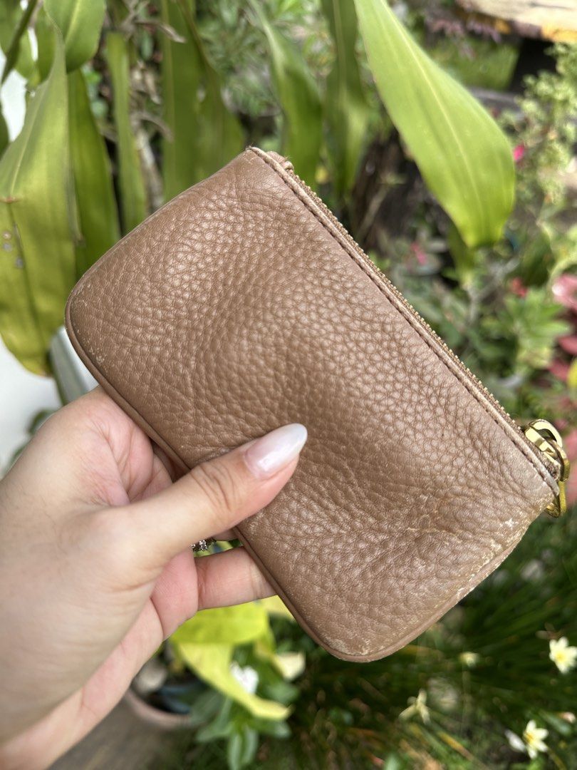 Marc by Marc Jacobs Brown Leather Zip Pouch (Category: Luxury Bags & Wallets) located in Bombon. Submitted by cookiespreloveed (Listing ID 1471161847, Image 3). Description: - Brand: Marc by Marc Jacobs - Material: Brown pebble leather - Hardware: Gold metal logo plaque and engraved round zipper pull - Function: Compact pouch ideal for storing cards, coins, and small essentials - Condition: Normal signs of wear along the bottom edges.