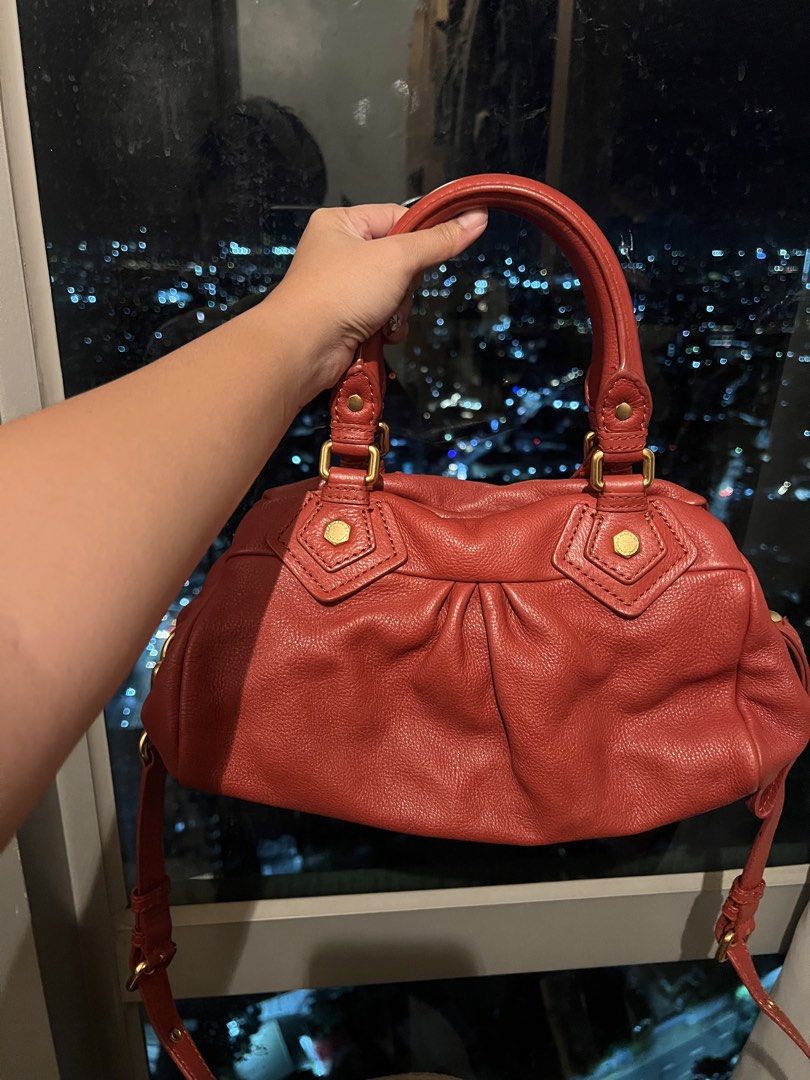 Marc by Marc Jacobs Red Leather Handbag (Category: Other Accessories) located in Imus. Submitted by ann__xoxo (Listing ID 1471177044, Image 3). Description: - Brand: Marc by Marc Jacobs - Material: Premium red leather with gold-tone hardware - Carry options: Structured top handles and a detachable shoulder strap - Closure: Secure top zip closure - Design details: Stylish gathered pleating on the front and a hanging metal logo plaque - Condition: 