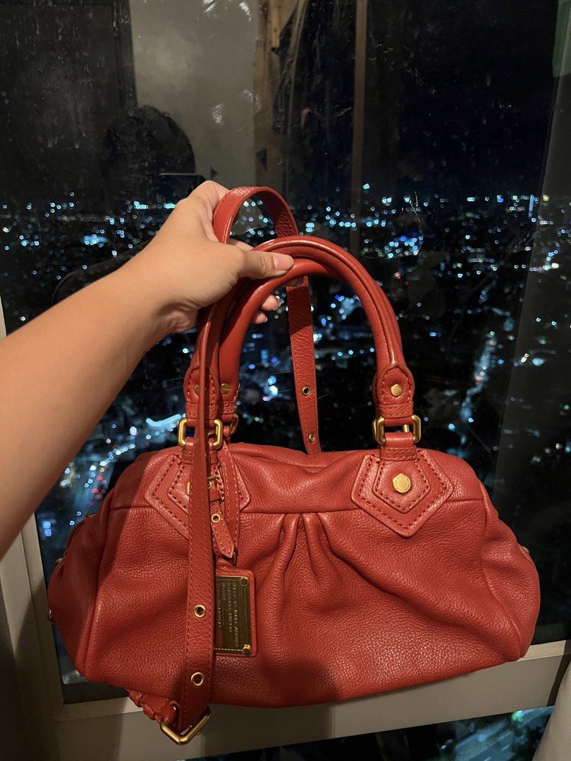 Marc by Marc Jacobs Red Leather Handbag (Category: Other Accessories) located in Imus. Submitted by ann__xoxo (Listing ID 1471177044, Image 1). Description: - Brand: Marc by Marc Jacobs - Material: Premium red leather with gold-tone hardware - Carry options: Structured top handles and a detachable shoulder strap - Closure: Secure top zip closure - Design details: Stylish gathered pleating on the front and a hanging metal logo plaque - Condition: 