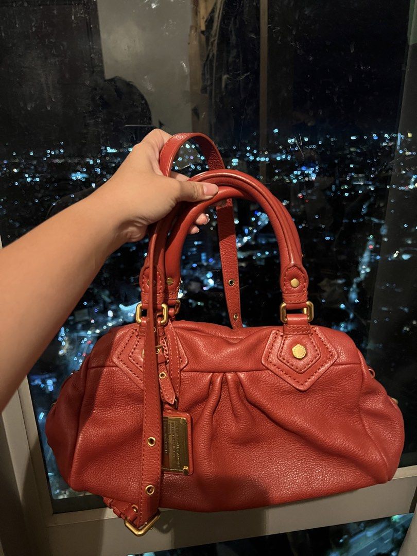 Marc by Marc Jacobs Red Leather Handbag (Category: Other Accessories) located in Imus. Submitted by ann__xoxo (Listing ID 1471177044, Image 2). Description: - Brand: Marc by Marc Jacobs - Material: Premium red leather with gold-tone hardware - Carry options: Structured top handles and a detachable shoulder strap - Closure: Secure top zip closure - Design details: Stylish gathered pleating on the front and a hanging metal logo plaque - Condition: 