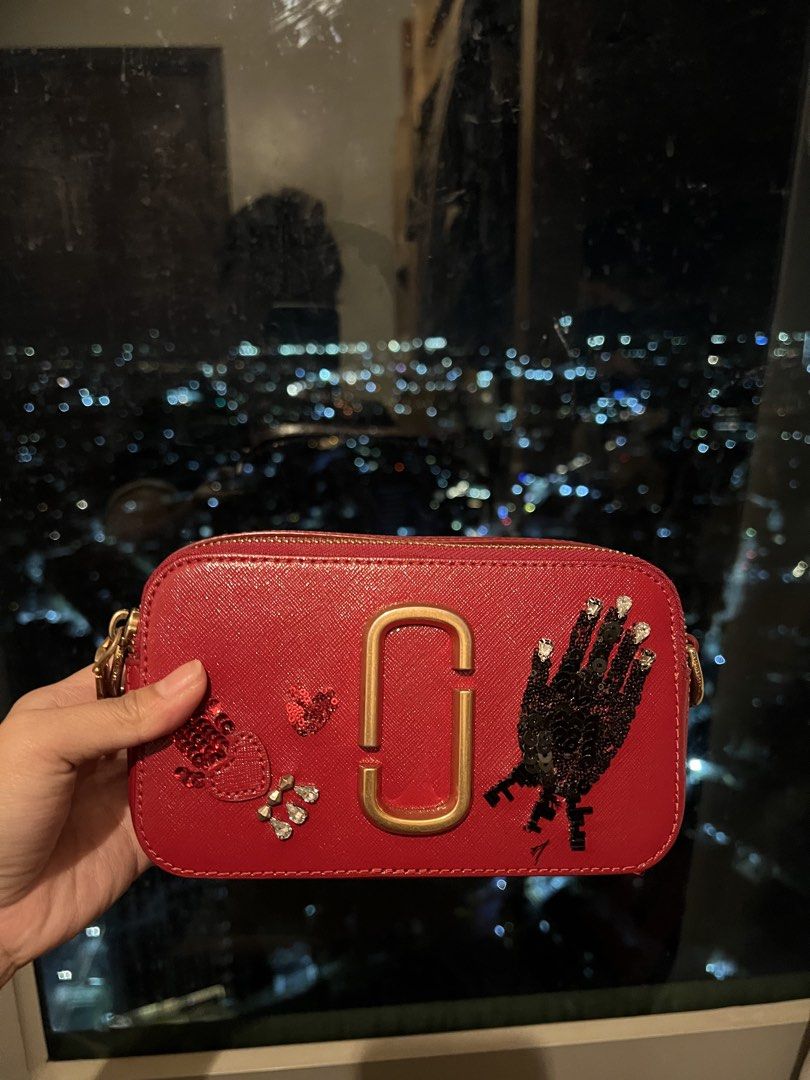 Marc Jacobs Red Snapshot Camera Bag with Embellishments (Category: Other Accessories) located in Imus. Submitted by ann__xoxo (Listing ID 1471179267, Image 1). Description: - Brand: Marc Jacobs - Style: Crossbody Camera Bag - Color: Red with gold hardware - Material: Durable Saffiano leather - Design: Unique sequin hand graphic and rhinestone bead details with gold foil branding - Compartments: Double zip compartments - Inclusion: Matching red st