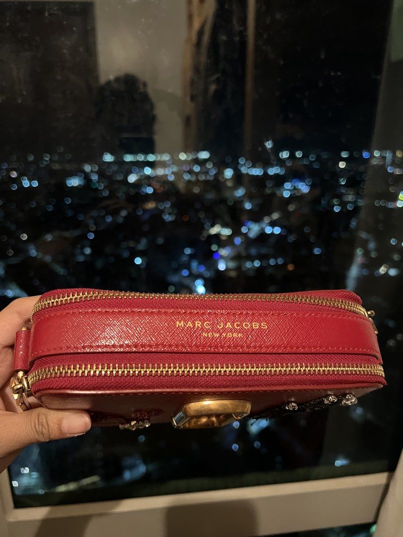 Marc Jacobs Red Snapshot Camera Bag with Embellishments (Category: Other Accessories) located in Imus. Submitted by ann__xoxo (Listing ID 1471179267, Image 2). Description: - Brand: Marc Jacobs - Style: Crossbody Camera Bag - Color: Red with gold hardware - Material: Durable Saffiano leather - Design: Unique sequin hand graphic and rhinestone bead details with gold foil branding - Compartments: Double zip compartments - Inclusion: Matching red st
