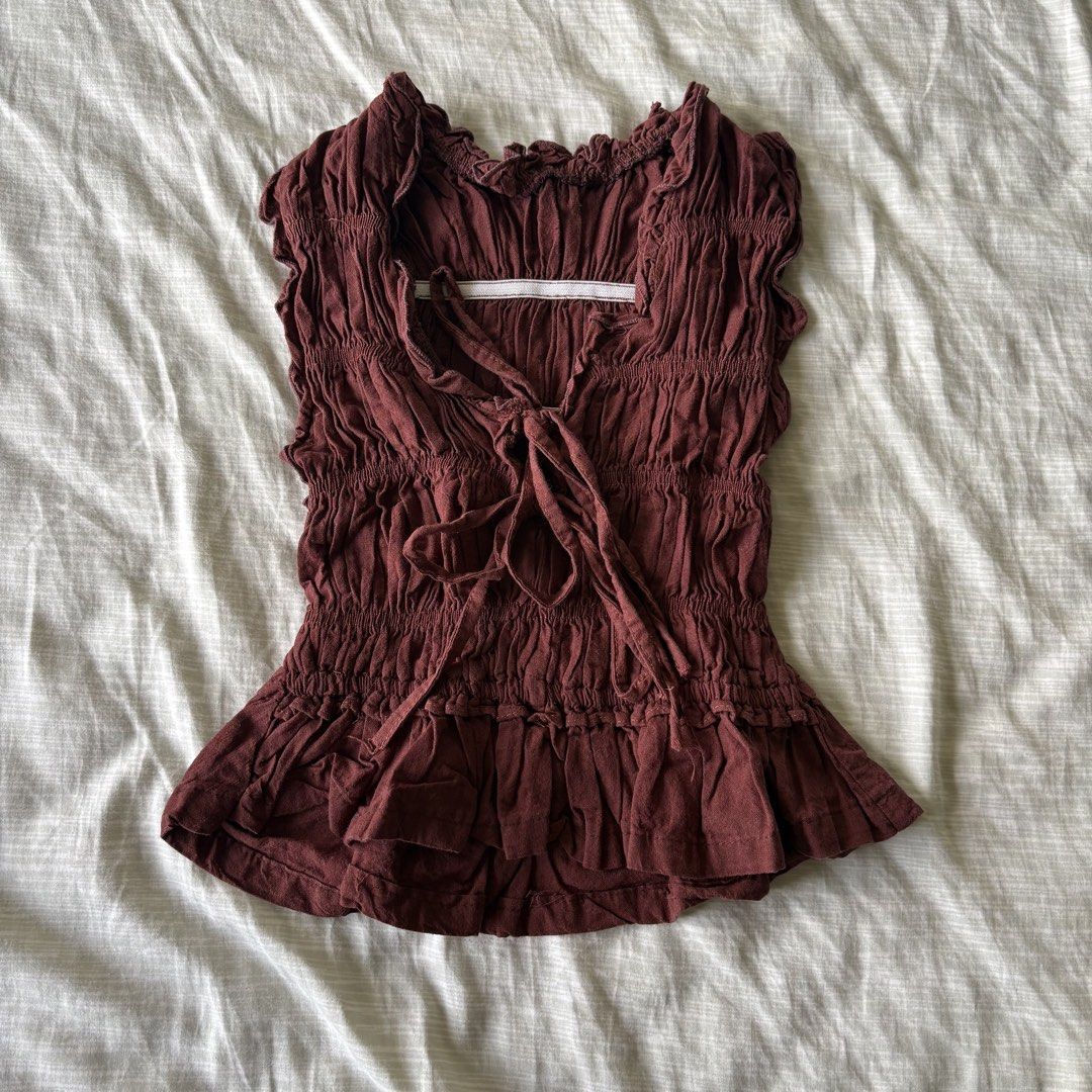 Maroon smocked sleeveless ruffle hem top tie front (Category: Sleeveless) located in Makati City. Submitted by jinlouise (Listing ID 1471144497, Image 1). Description: - Color: Maroon - Material: Lightweight, super stretchy cotton - Design: All-over heavy smocking with front ribbon tie closure - Details: Ruffle shoulder trim and flared peplum hem - Styling: Perfect for casual everyday wear or paired with high-waisted denim Note: •used it once onl