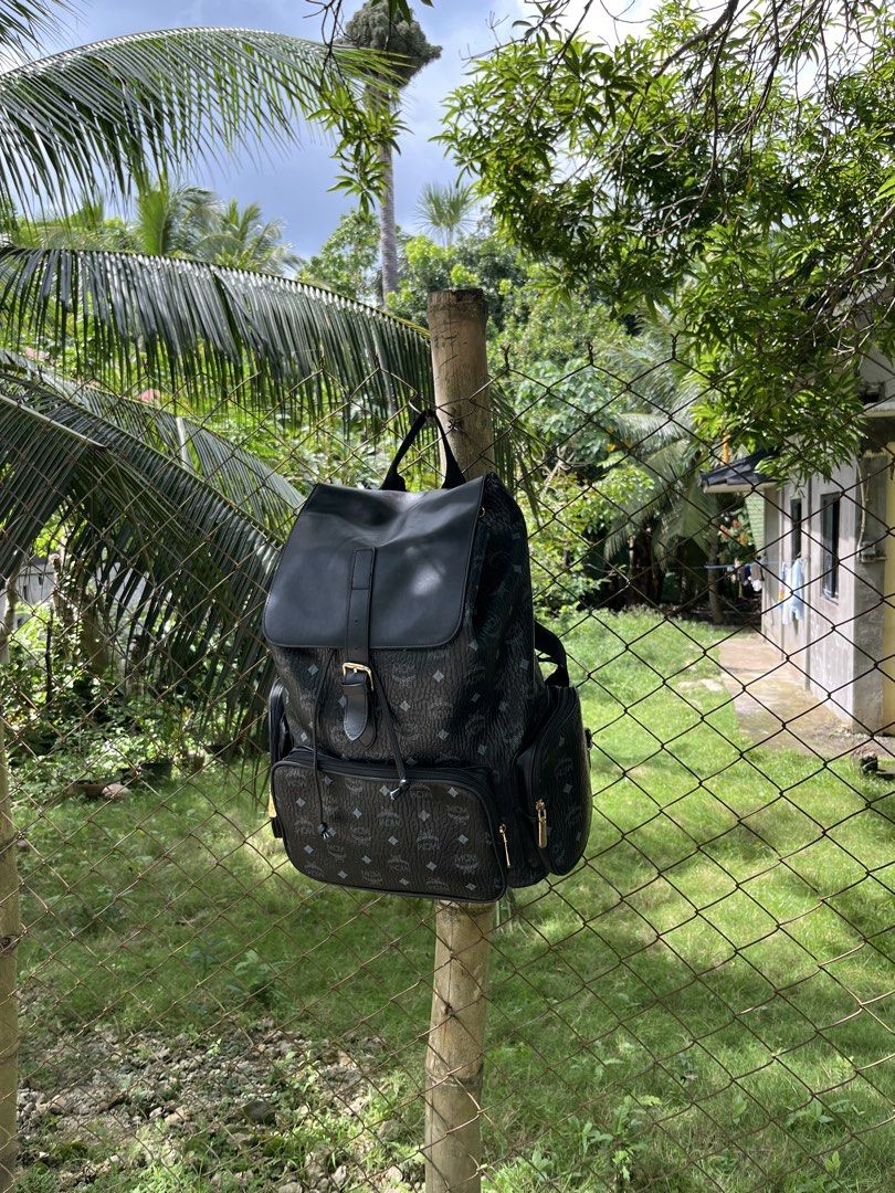 MCM Black Monogram Leather Flap Backpack (Category: Luxury Bags & Wallets) located in Quezon City. Submitted by reluxefinds2025 (Listing ID 1471207748, Image 1). Description: - Brand: MCM - Color: Classic Black with gold-tone hardware - Design: All-over MCM monogram print with solid black leather flap top and buckle strap closure - Pockets: Front zip pocket and convenient side utility pockets - Interior: Spacious main compartment that easily fits