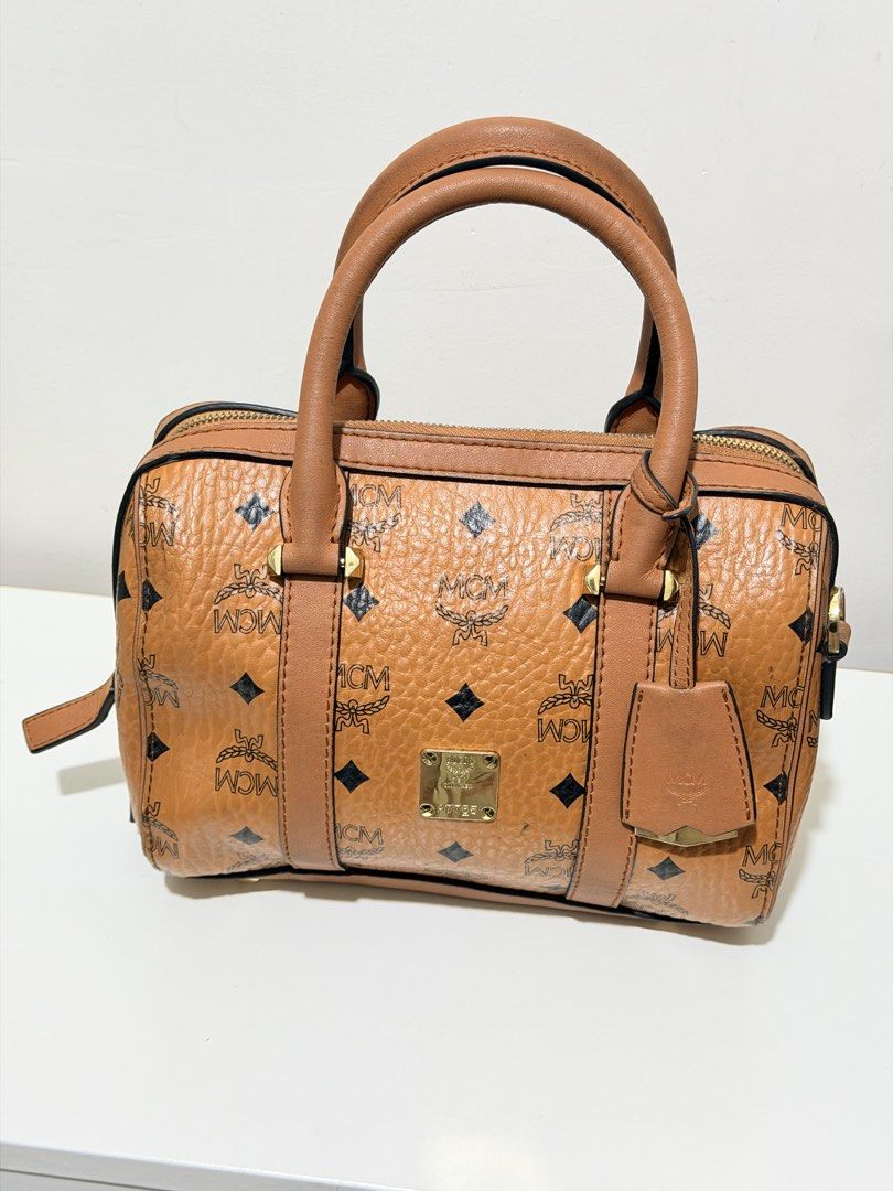 MCM Cognac Visetos Boston Bag (Category: Luxury Bags & Wallets) located in Paranaque City. Submitted by diannmlee (Listing ID 1471207170, Image 1). Description: Needs cleaning Sign of usage No sling I bought this sa Tiktok live selling ng ukay bags and never used it. Impulse buy lang. It looks and feels legit. I am not 💯 sure though. Bag condition: 7.5/10.