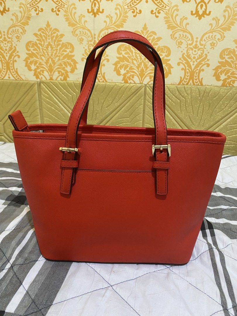 Michael Kors Red Saffiano Leather Tote Bag (Category: Tote Bags) located in Pasay City. Submitted by honey.gee11 (Listing ID 1471171701, Image 2). Description: - Authentic Michael Kors bright red handbag in structured Saffiano leather - Elegant gold-tone hardware and front logo lettering - Dual top carry handles and secure top zip closure - Exterior back slip pocket for easy access - Clean interior featuring zipper and slip compartments - Structu