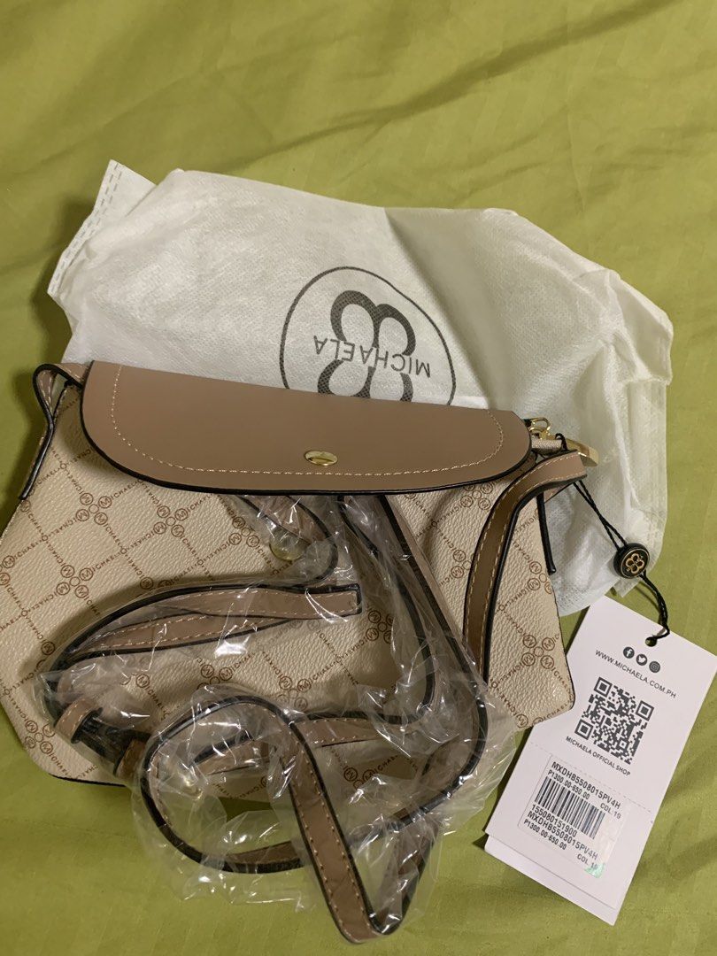 MICHAELA Monogram Crossbody Bag Cream and Brown (Category: Cross-body Bags) located in Manila. Submitted by angelyrrehc (Listing ID 1471141479, Image 2). Description: -Cream and brown patterned crossbody bag from MICHAELA. -Tan flap closure on the front with gold hardware. -Includes a matching adjustable strap wrapped in plastic, original dust bag, and store tag attached. -Zipper closure underneath the flap. Clean structured design. -size : 8.5x6