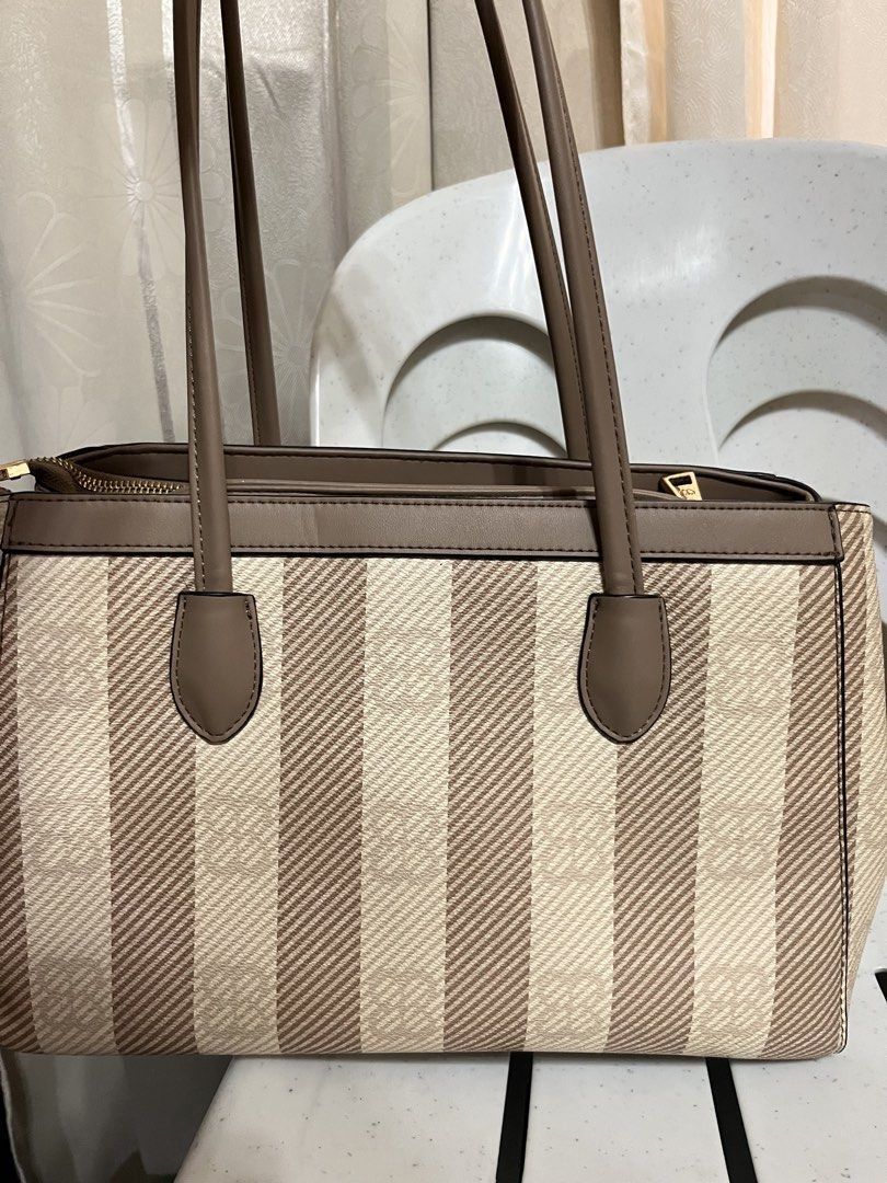 MICHAELA Striped Tote Bag Brown Beige (Category: Tote Bags) located in Koronadal. Submitted by hiiiii.hello (Listing ID 1471130923, Image 2). Description: - Color: Classic brown and beige stripes - Hardware: Elegant gold-toned details - Straps: Sturdy and comfortable for shoulder wear - Interior: Multiple zippered compartments for easy organization - Lining: Clean fabric with stylish logo prints.